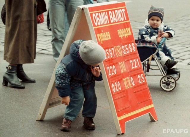  Dítě hraje na schovávanou a-hledat pod desku nesoucí směnných kurzů v centru Kyjeva 21.října 1998. Foto: EPA